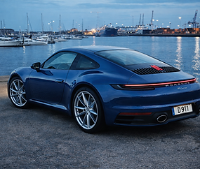 blue porsche 911 with the waterfront