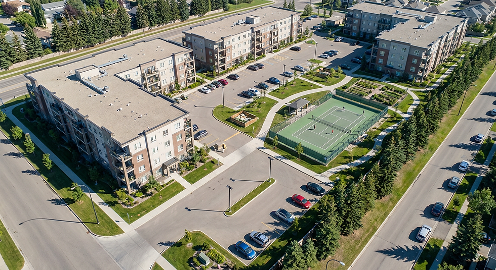 Aerial view of a newer condominium complex with parking and amenity areas