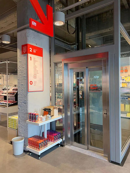 HEMA retail wayfinding design with red lift signage and floor directory inside the store environment.