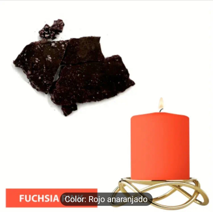 Fragmentos de resina oscura junto a vela fucsia