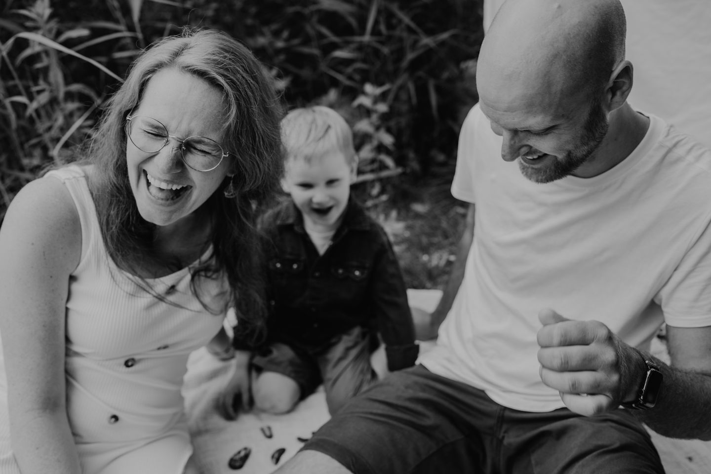 Foto einer Familie am Strand. Alle lachen.