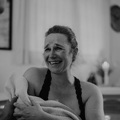 Geburtsfotografie in Flensburg. Frau hält Neugeborenes in den Armen