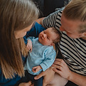 Newbornfotografiein Flensburg. Vater und Mutter halten Baby im Arm