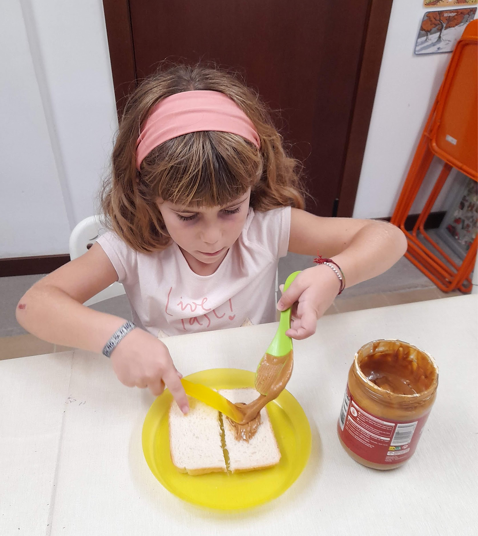 Young student preparing a Peanut Butter & Jelly sandwich during an American culture activity at DarKha Academy in Xàtiva, learning English through cooking and hands-on cultural experiences.