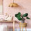 Thumbnail: rotan hanglamp in de vorm van een bloem in een kinderkamer met roze behang