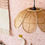 Thumbnail: rotan hanglamp in de vorm van een bloem in een kinderkamer met roze behang