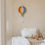 Thumbnail: houten kinderlamp in de vorm van een luchtballon in retro kleuren in een lichte neutrale kinderkamer