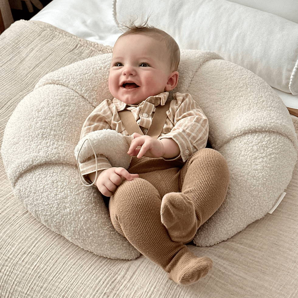 voedingskussen in de vorm van een croissant met lachende baby