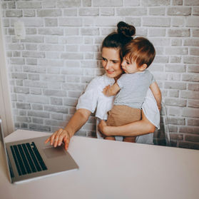 An image of a parent with their child on a laptop looking at flexible working for parents in North Lanarkshire