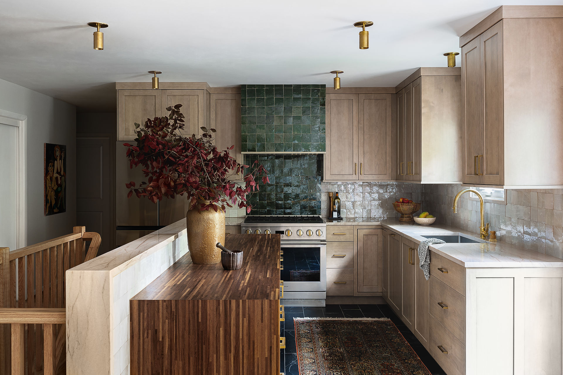 completed kitchen by Erika Jayne Design Build in Maryland featuring a walnut waterfall island, zellige tiles, a tiled hood, quartzite countertops, and brass fixtures