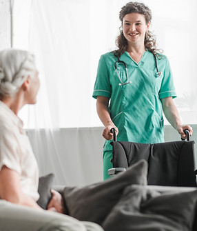 senior-woman-looking-smiling-female-nurse-with-wheelchair.jpg