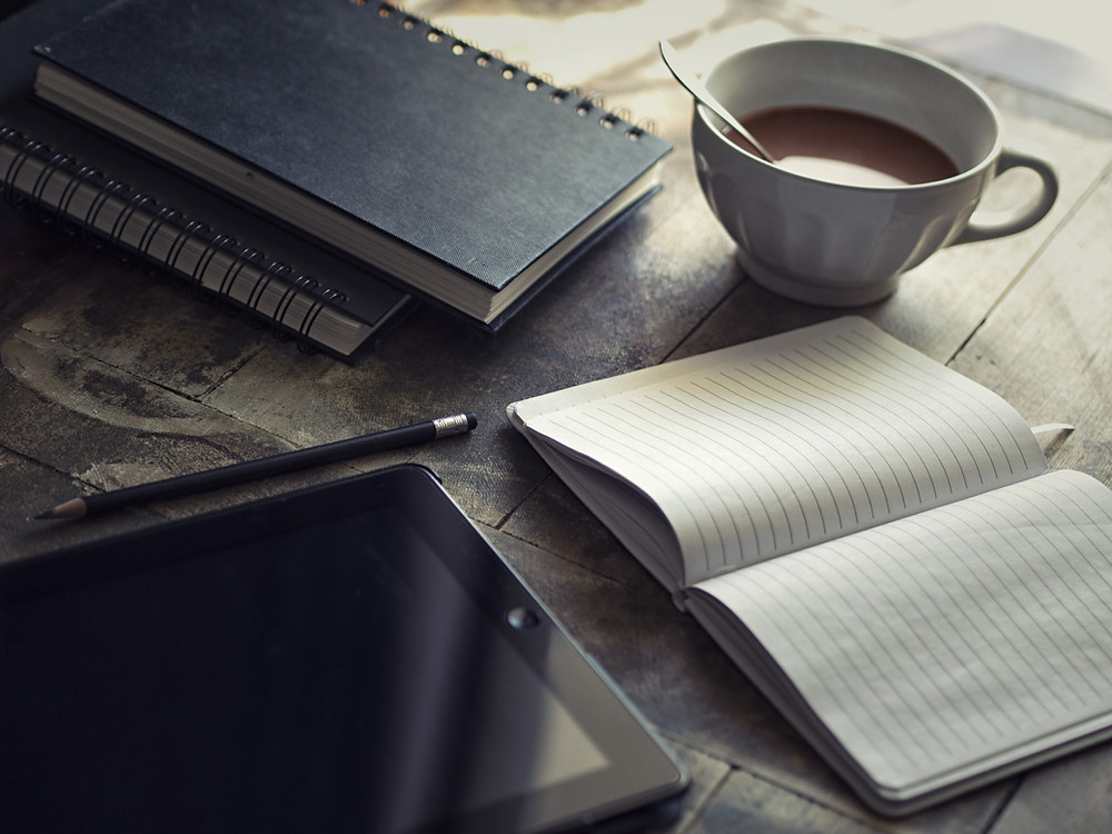 Blogging with tablet, notebooks, and coffee