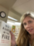 Elaina holding up a book at the library