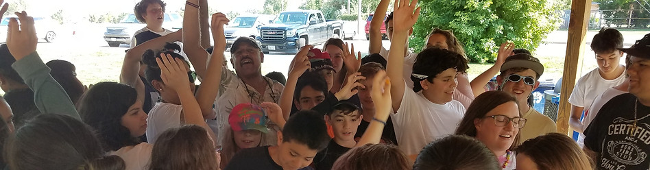 parents and students raising hands in celebration under a pavilion