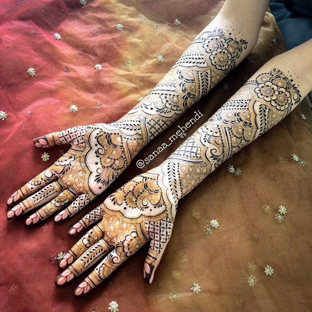 An intricate and strikingly beautiful henna design on the hands’ of a bride (up to her elbows).