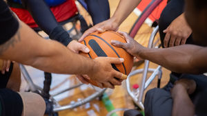 Wheelchair basketball players working together as a team, representing activities included in an NDIS STA or respite stay.