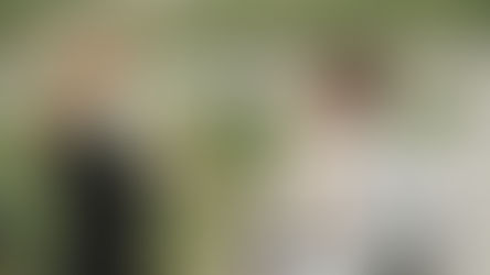 A woman in a wheelchair and a child enjoy a playful outdoor moment, smiling warmly.