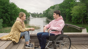 A couple enjoys time together by the river, highlighting love and support.