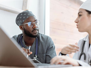 Two healthcare workers in conversation, focusing on collaboration and patient care.