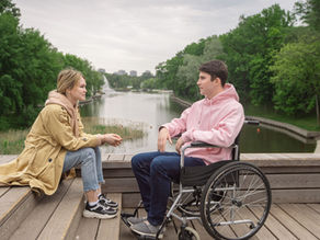 A couple enjoys time together by the river, highlighting love and support.