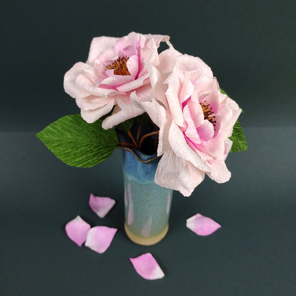 Thumbnail: Two paper open roses with leaves in a blue ceramic vase