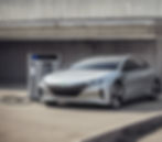 Silver electric car charging at station