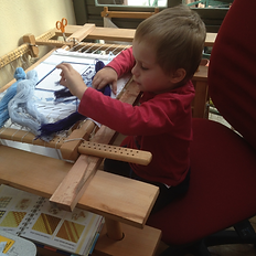historic tapestry ,childern sewing at slate frame and tressles, young craftsman