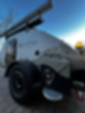 A side view of a PinDrop with a water jug mounted to the side of the trailer, in a branded aluminum case.