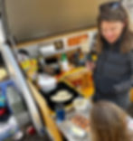 Woman making breakfast on the two burner propane stove.
