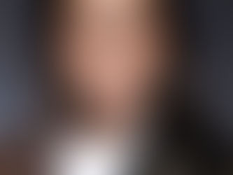 Professional headshot of a confident individual in business attire, photographed at Tals Studio in NYC with a clean studio background.