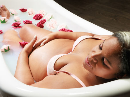 Maternity milk bath session in NYC with blue milk and floral accents at Tals Studio