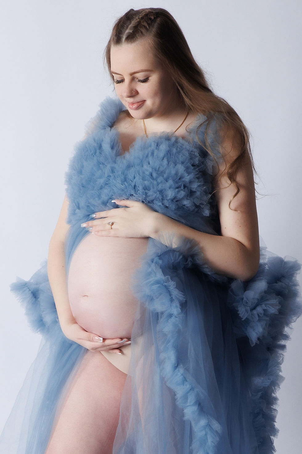 Pregnant woman smiling during a maternity photoshoot at Tals Studio NYC
