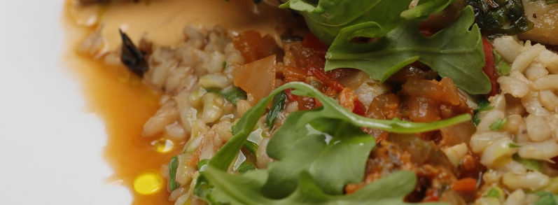 Herb-crusted sea bass with rice, greens and creamy sauce