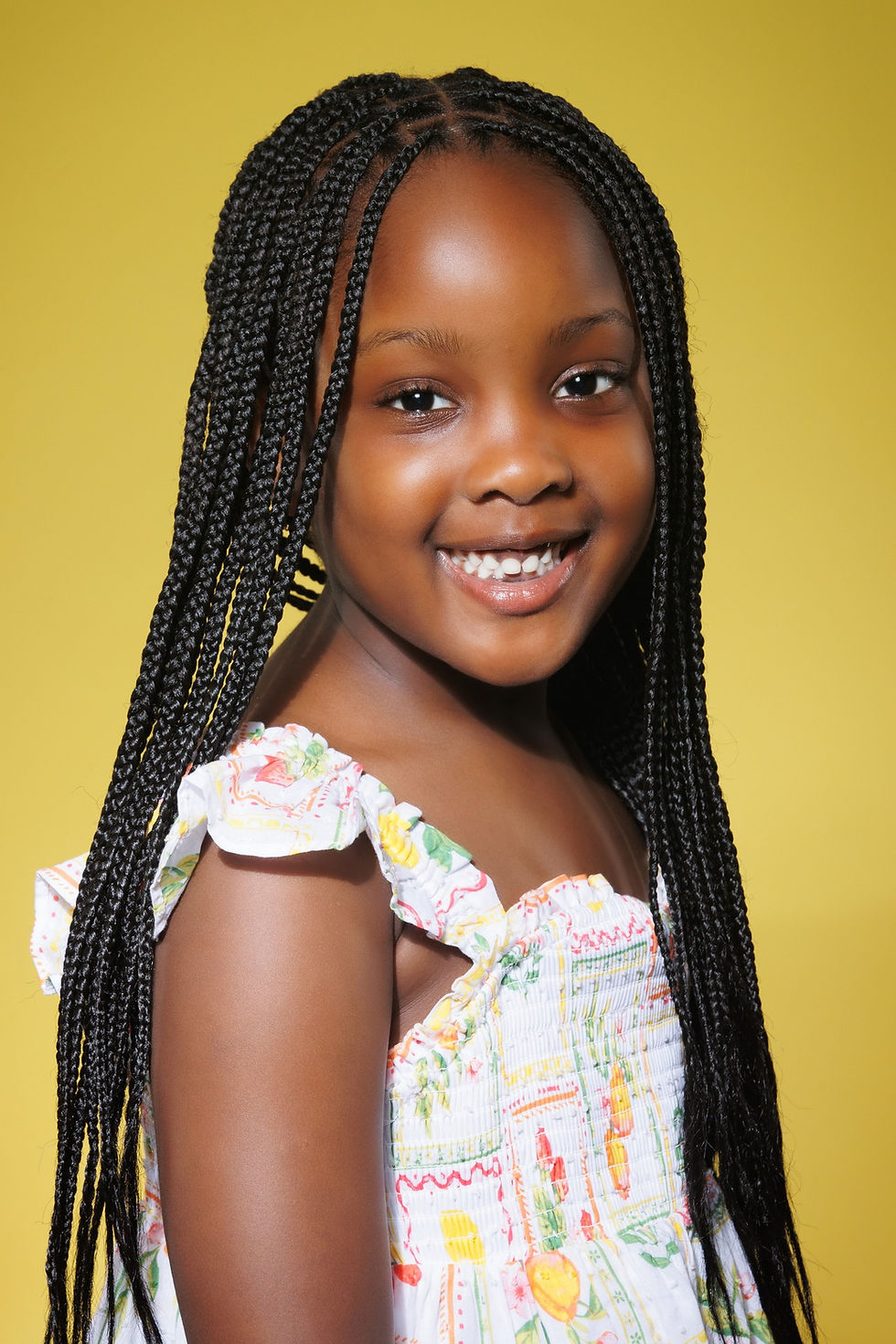 Kids acting headshot in NYC featuring a child smiling naturally with clean background and professional lighting.