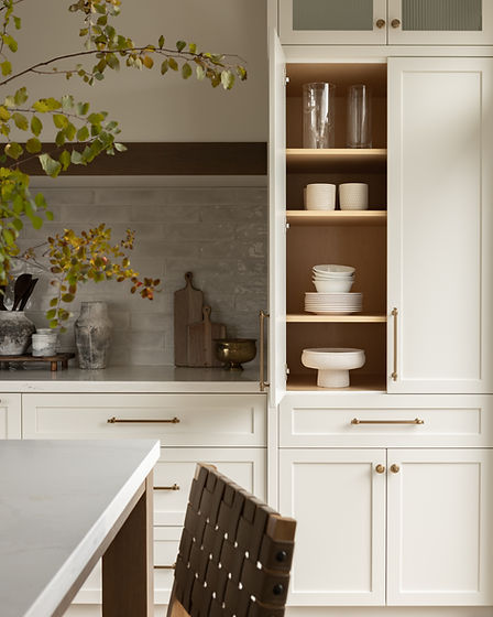 Styled kitchen with open cabinet of dishes, set up for a second home