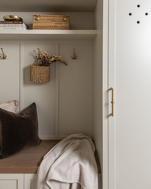 Mudroom bench with a woven basket and hooks in a Whitby home kept organized by DECANTT