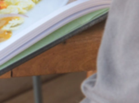 Kochbuch liegt geöffnet auf einem Tisch.