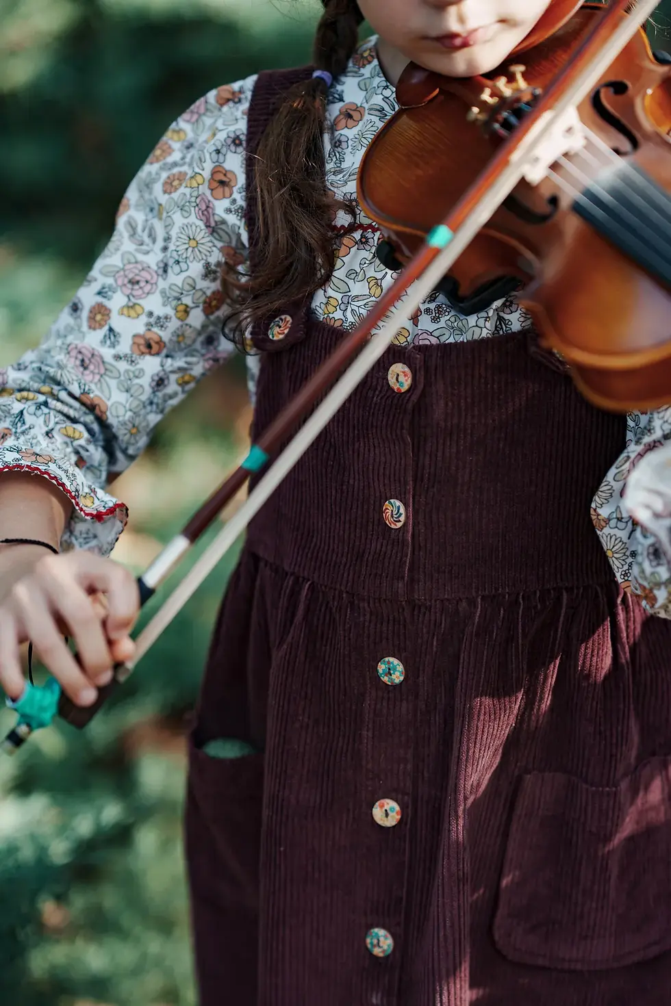 Küçük resim: Mürdüm renkli fitilli kadife jile giyen çocuk keman çalıyor