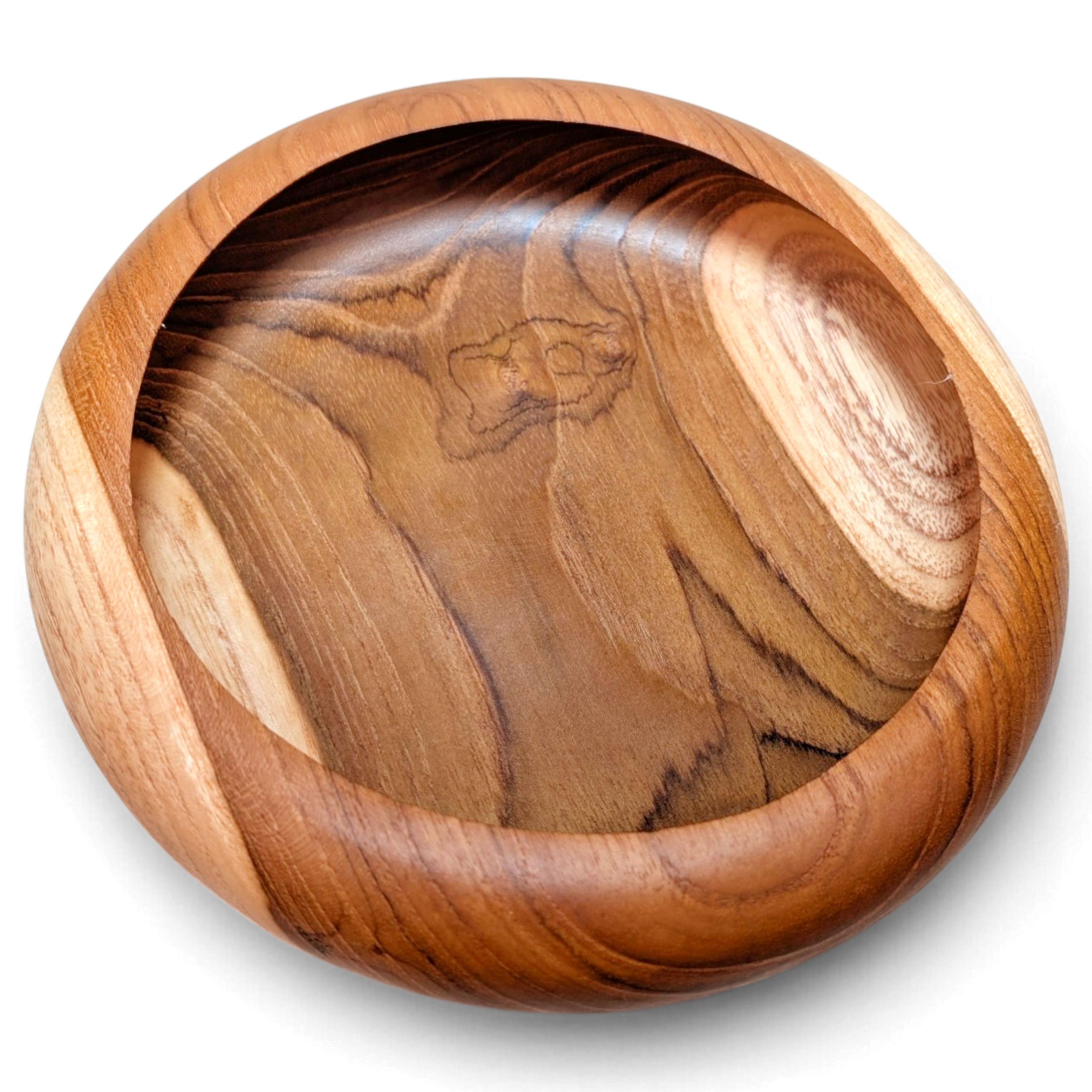 Close-up of a round teak serving bowl displaying its warm natural grain