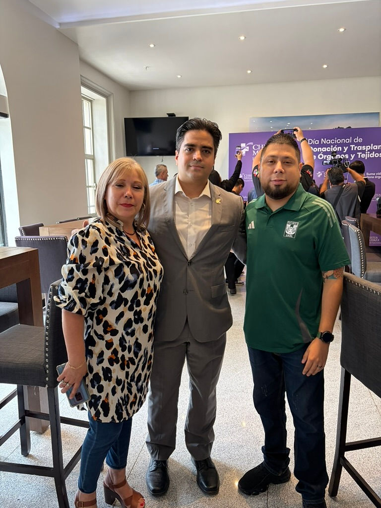 Tres personas sonriendo en un evento