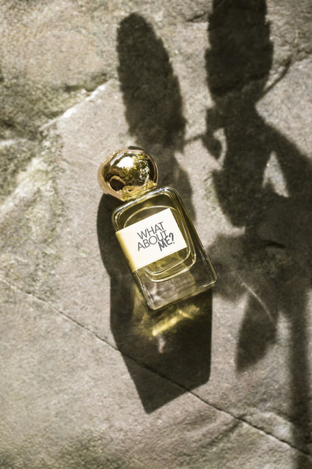 Luxury perfume bottle on natural stone with sunlight and leaf shadow — modern, minimalist, nature-inspired high-end product photography.