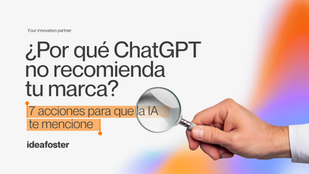 Imagen editorial de Ideafoster con una mano sosteniendo una lupa y el titular “¿Por qué ChatGPT no recomienda tu marca? 7 acciones para que la IA te mencione”, sobre un fondo blanco con gradientes naranjas y violetas.