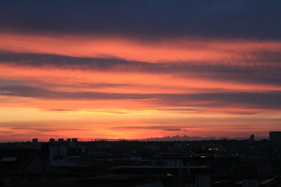 Dramatic orange and red sunset sky over a dark city horizon, private jet catering at Brussels Airport (BRU / EBBR), Zaventem, Belgium