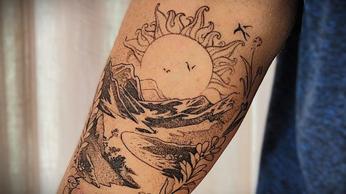 Tatuagem com sol, caminho e flores simbolizando luz e liberdade