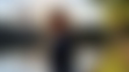 Homem olhando o horizonte, em ambiente urbano, com um lago no fundo e céu azul