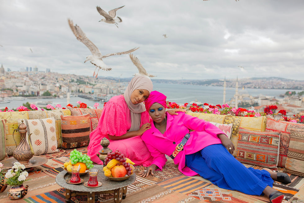 two women wearing bright colour on a roof top setting