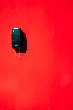 minimalist red and black photograph of a detail of a residence entrance in Paris