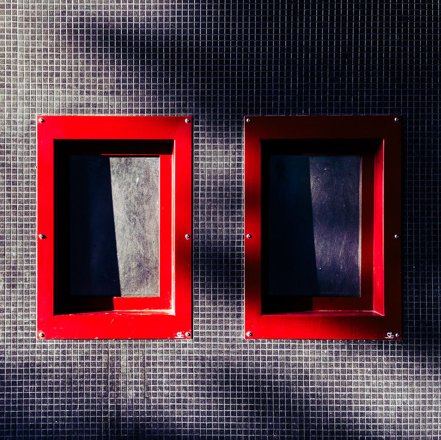 Photographie urbaine géométrique et artistique de deux fenêtres avec contraste rouge dominant