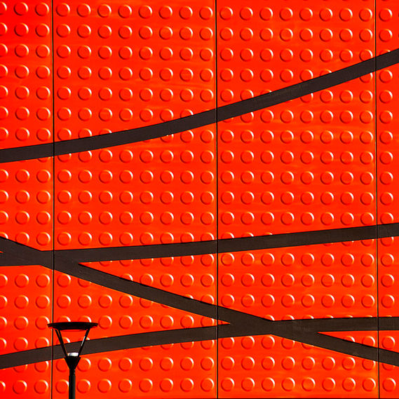 image minimaliste d'un mur rouge avec des formes noires très graphiques