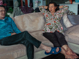 Painting of a Vietnamese Canadian couple sitting on their living room couch